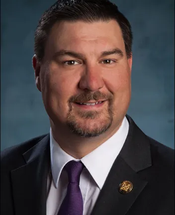 Professional man in suit with purple tie and lapel pin