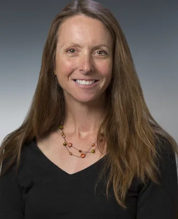Professional headshot of woman with long hair smiling