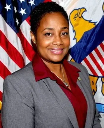 Professional woman standing in front of U.S. flags